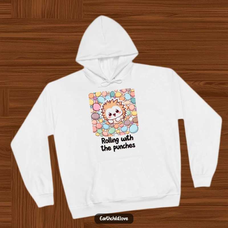 Funny Kawaii hedgehog rolling happily amongst colorful pebbles, a cozy and playful hoodie design.